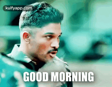 a man with a mustache is smoking a cigarette and says good morning .