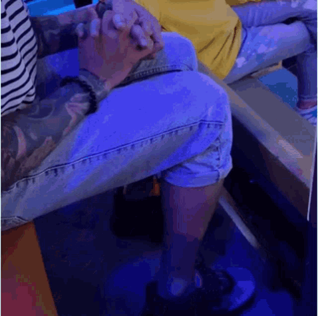 a man and woman are sitting on a bench holding hands .