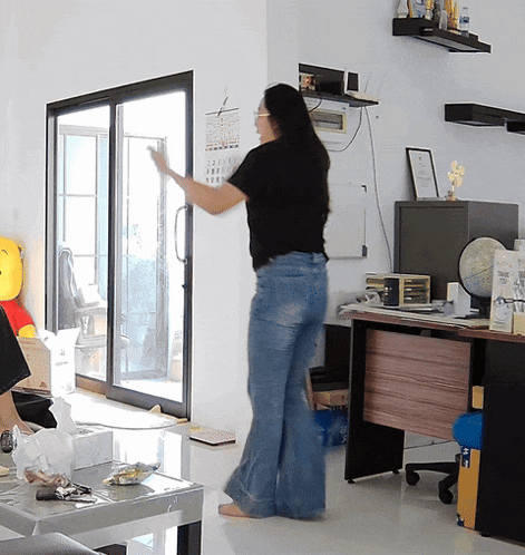 a woman in a living room with a calendar on the wall that shows the month of october