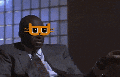 a man in a suit and tie is wearing a mask with a cat on it