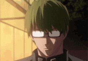 a man with green hair and glasses is looking at the camera