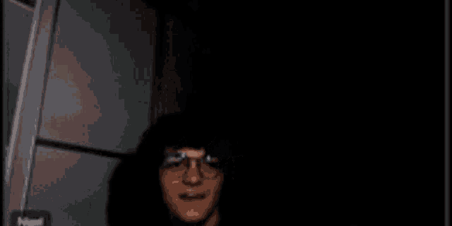 a blurry picture of a man wearing glasses and a hat .