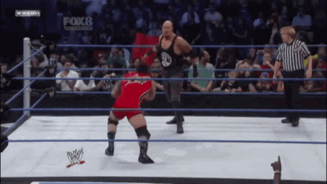 two wrestlers in a wrestling ring with fox 8 on the bottom left