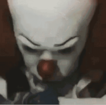 a close up of a clown with a red nose and a white face .
