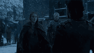 a man is carrying a woman in his arms in the snow in a scene from game of thrones .