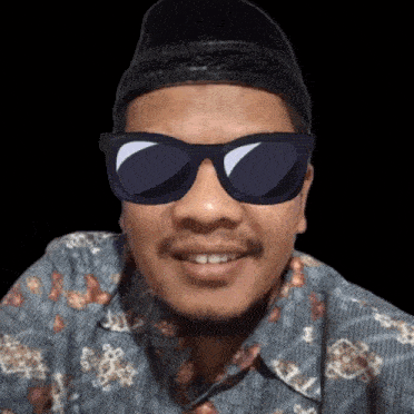 a man wearing a hat and sunglasses is smiling