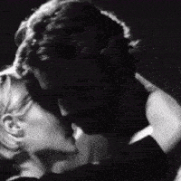 a man and woman are kissing in a black and white photo