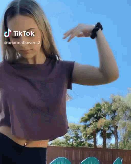 a woman in a crop top is flexing her muscles in a tiktok video