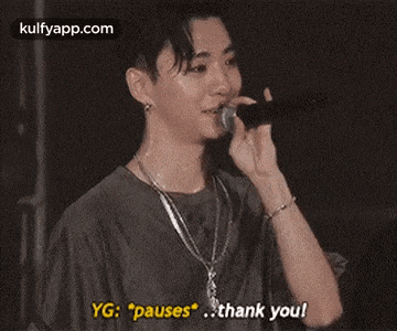 a young man is singing into a microphone and saying `` pauses `` .