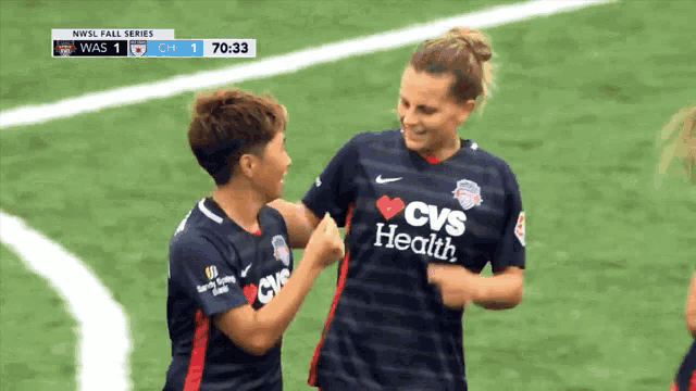 two soccer players wearing cvs health jerseys are hugging