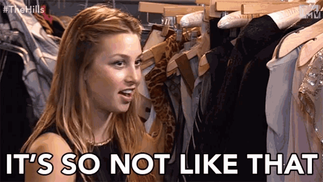 a woman is standing in front of a rack of clothes and the words it 's so not like that are above her
