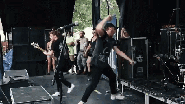 a man is dancing on a stage with a microphone