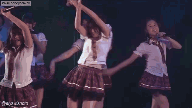 a group of girls in school uniforms are dancing on stage