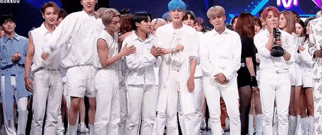a group of young people are standing next to each other on a stage in front of a crowd .