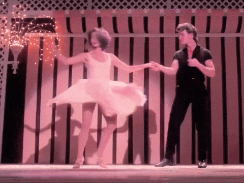 a woman in a pink dress is dancing with a man
