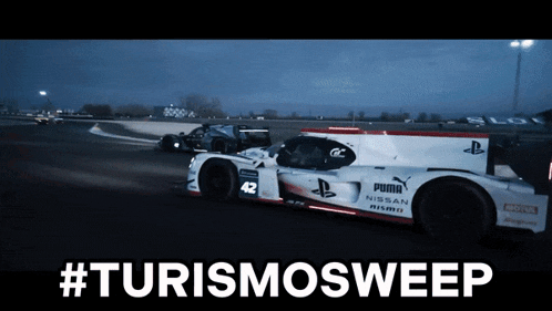 a nissan nismo race car is driving down a track at night
