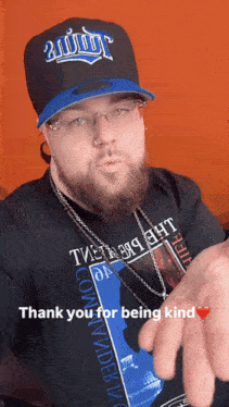 a man with a beard wearing a hat and a shirt that says thank you for being kind