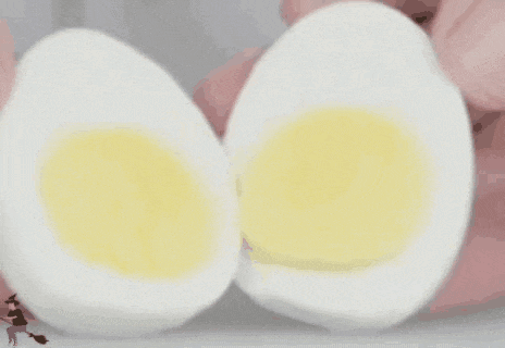 two hard boiled eggs are being cut in half on a table