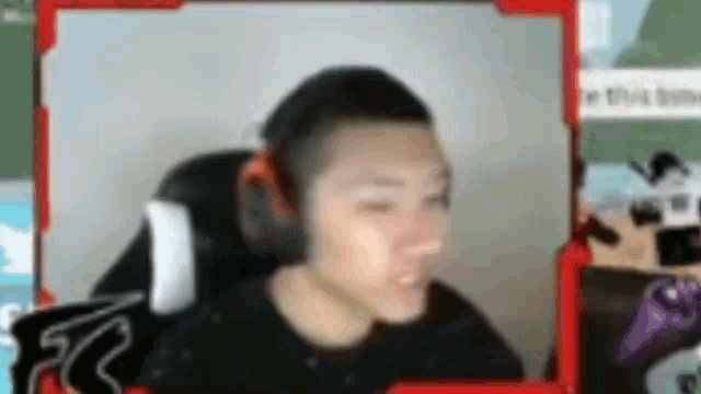 a man wearing headphones is sitting in a chair on a video call .