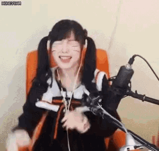 a girl is sitting in a chair in front of a microphone .