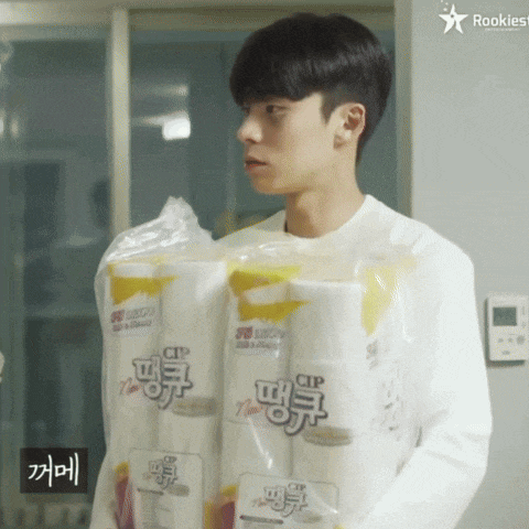 a young man is carrying a stack of toilet paper that says ' cp ' on it