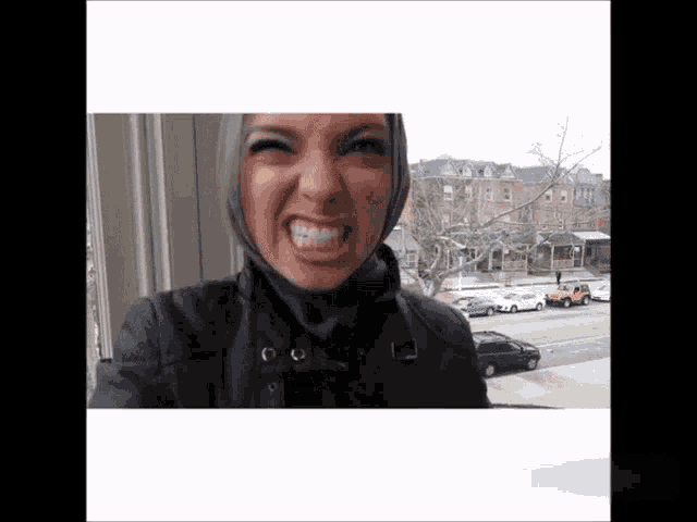 a woman wearing a hijab making a funny face