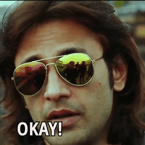 a man wearing sunglasses says " okay " in front of him