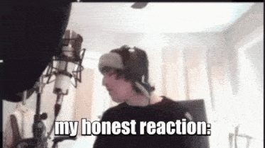 a man wearing headphones is standing in front of a microphone with the words `` my honest reaction '' below him .