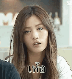 a woman with long hair is making a funny face with a foreign language .