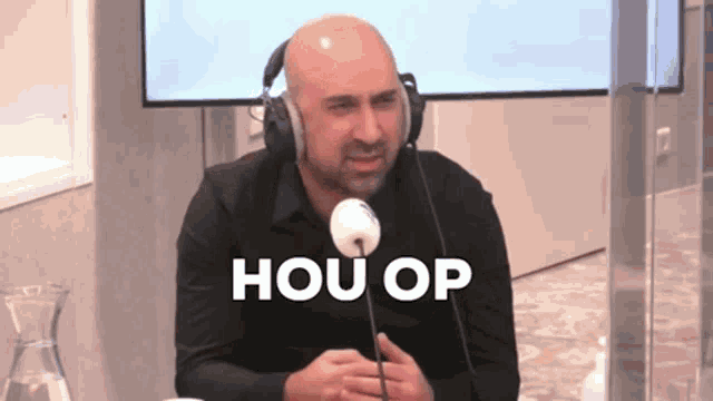 a man wearing headphones is sitting in front of a microphone and the words hou op are above him
