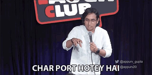 a man is holding a microphone in front of a sign that says " char port hotey hai "