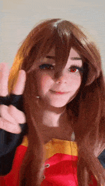 a girl with long brown hair and red eyes is giving a peace sign .