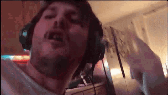 a man wearing headphones and a white shirt is dancing