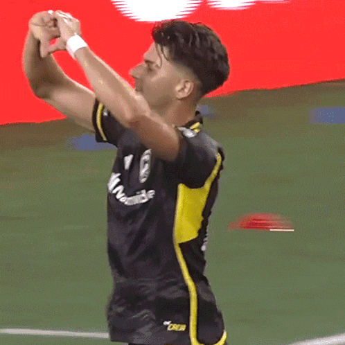 a soccer player wearing a black and yellow jersey that says oakland on it