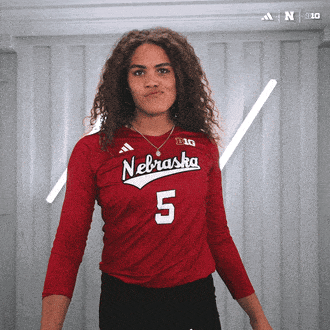 a woman wearing a red nebraska jersey with the number 5