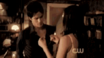 a man and a woman are standing next to each other in a dark room .