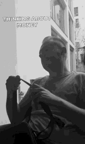 a black and white photo of a man with the words thinking about money below him