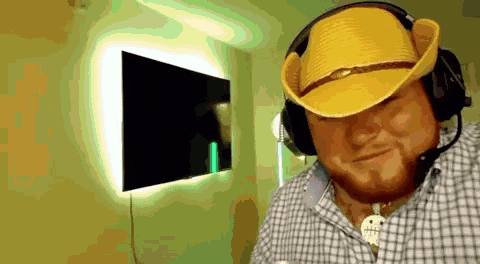 a man wearing a cowboy hat and headphones is smiling