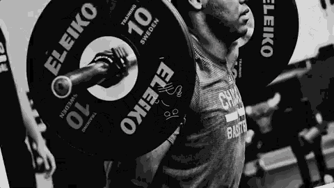 a black and white photo of a man lifting a barbell that says eleiko