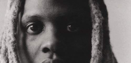 a black and white photo of a person 's face with dreadlocks