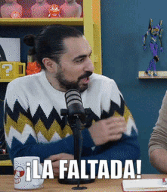 a man sitting in front of a microphone with the words " la faltada " written on the bottom