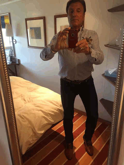 a man taking a selfie in front of a mirror