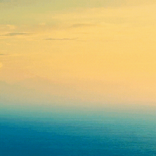 a sunset over the ocean with a yellow sky