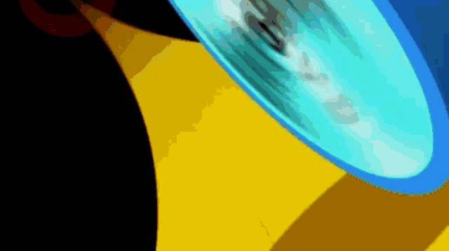 a blue object is spinning on a yellow and black surface .