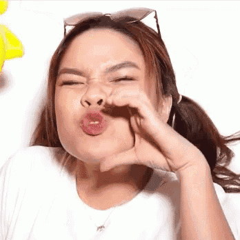 a woman wearing sunglasses is making a funny face with her hand on her face .