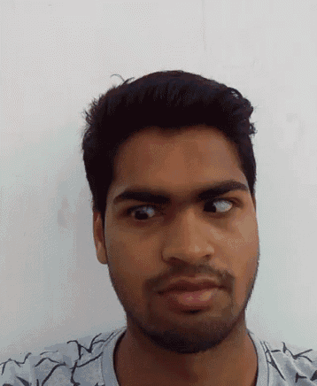 a young man with a beard looks at the camera with his eyes closed