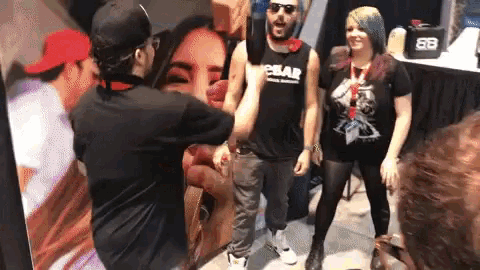 a man wearing a tank top that says ebay stands next to a woman
