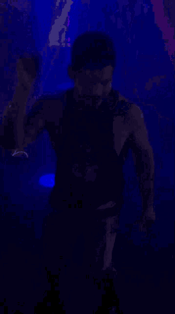 a silhouette of a man in a dark room with blue lights
