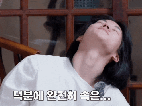 a woman laying on a chair with her eyes closed and korean writing on the bottom