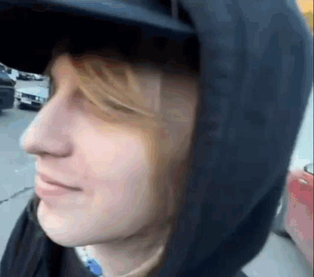 a close up of a person 's face wearing a hoodie and a hat .